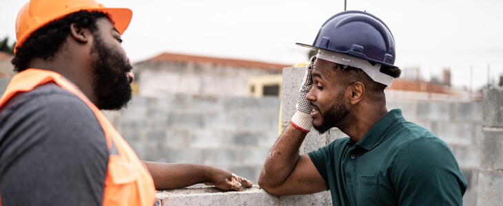 Male construction worker consulting with a colleague on the construction site