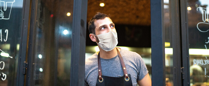 Restaurant owner opening his store's doors while looking at the sky