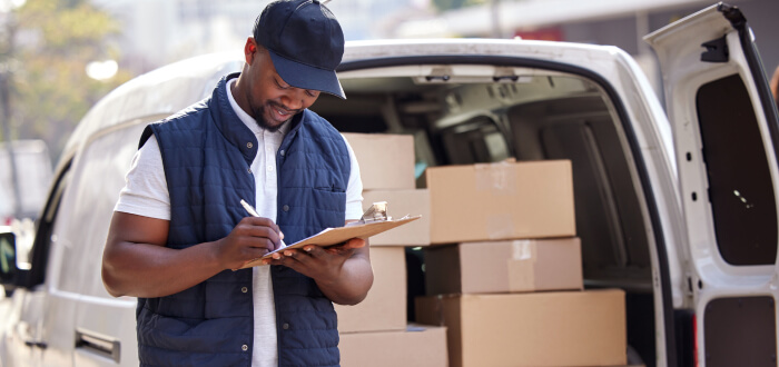 A delivery driver checks off that all the orders are ready to ship