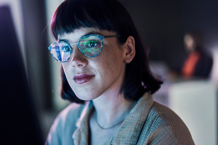 business woman sits at computer into evening hours