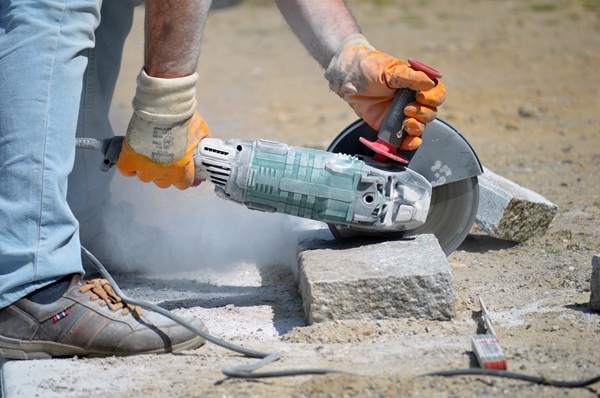 Construction worker cutting stone.